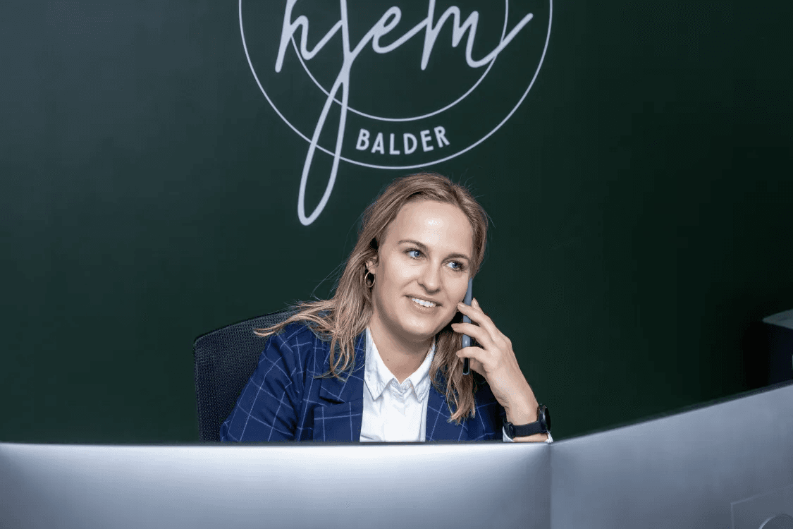 Heidi, an employee at Balder Denmark, sits at her computer while speaking on the phone.