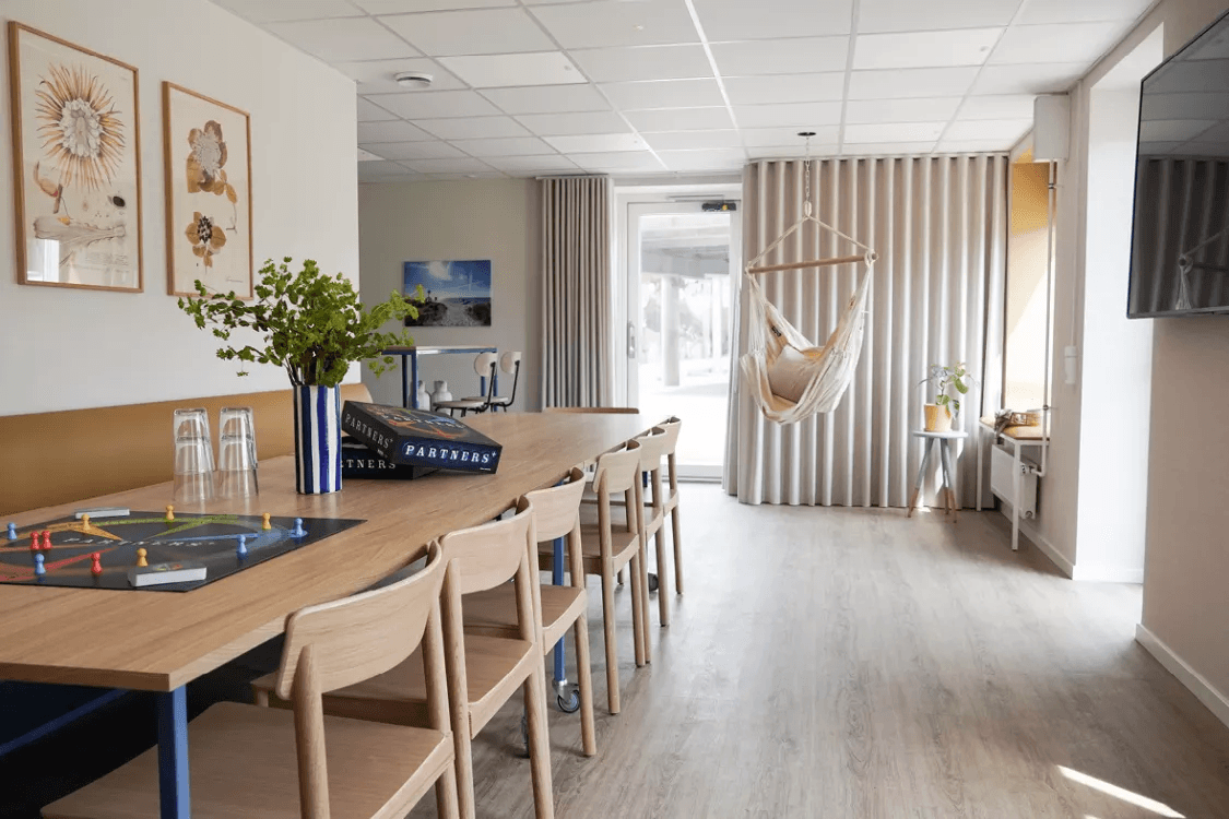The common room with tables and chairs at the Strandby Høje property in Hundige