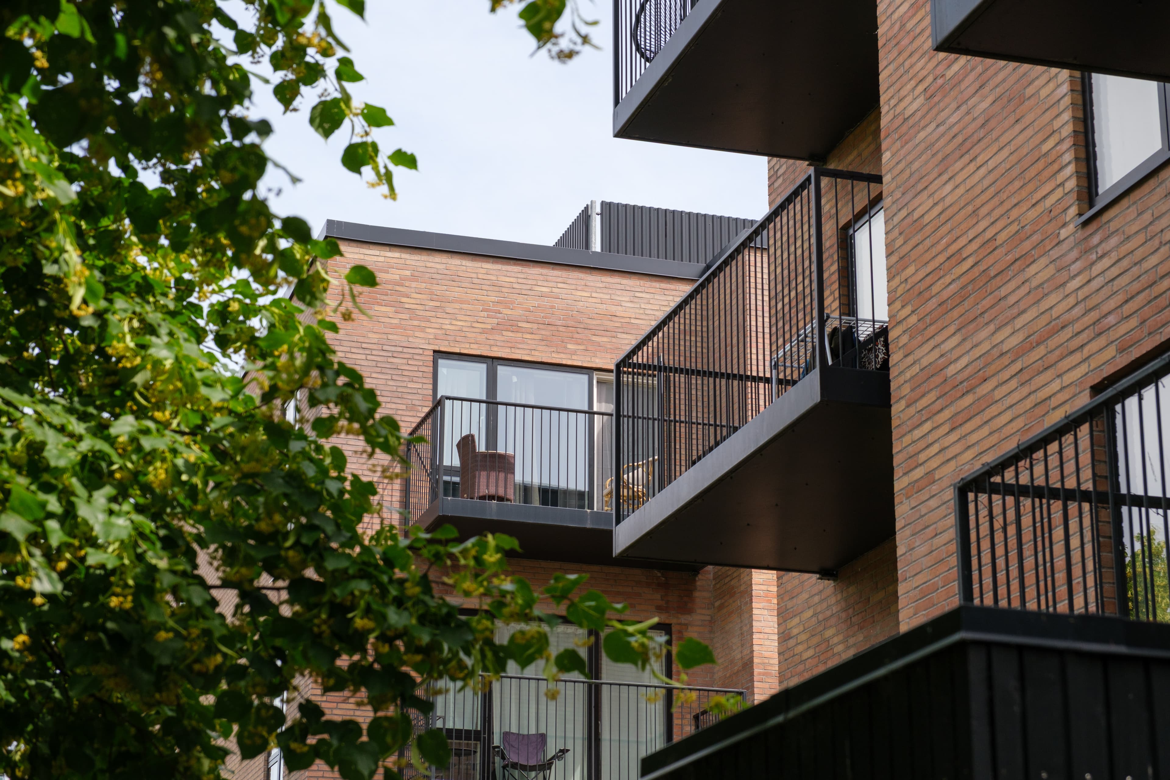 Facade med altaner og grøn beplantning. Ejendommen er Agerhusene, som er placeret i Høje-Taastrup.