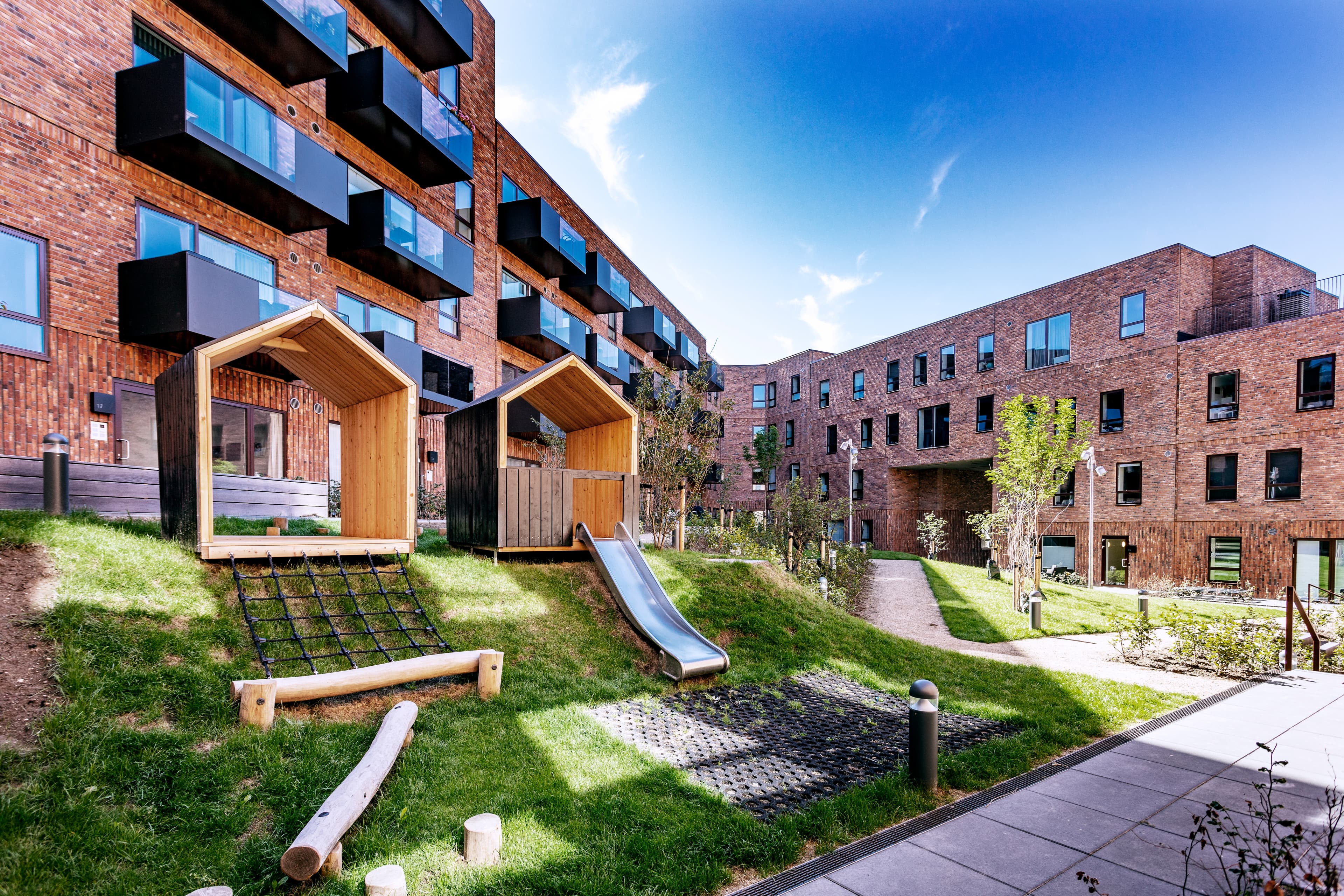 Eksteriørfoto af legepladsen ved Carlsbakken i Hillerød, placeret i gårdmiljøet.