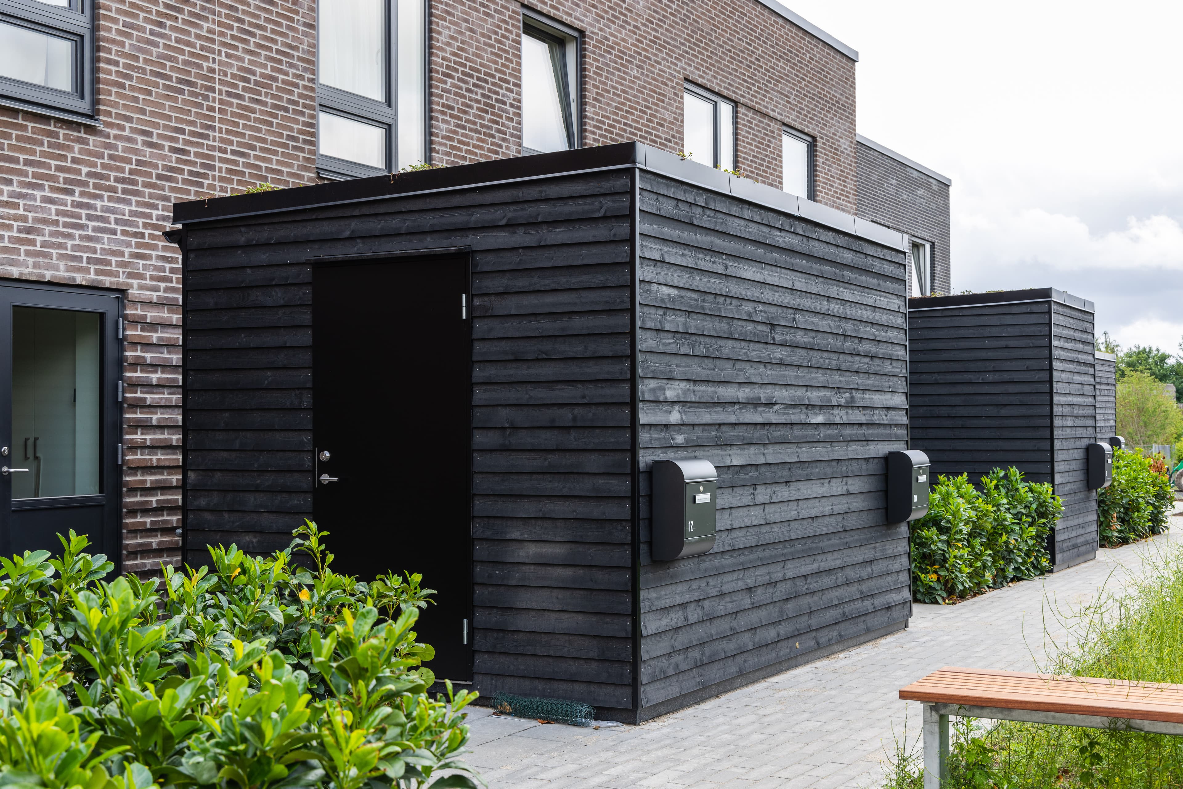 This photo shows the façade and the associated bike shed for the TriumphHusene terraced houses in Espergærde.
