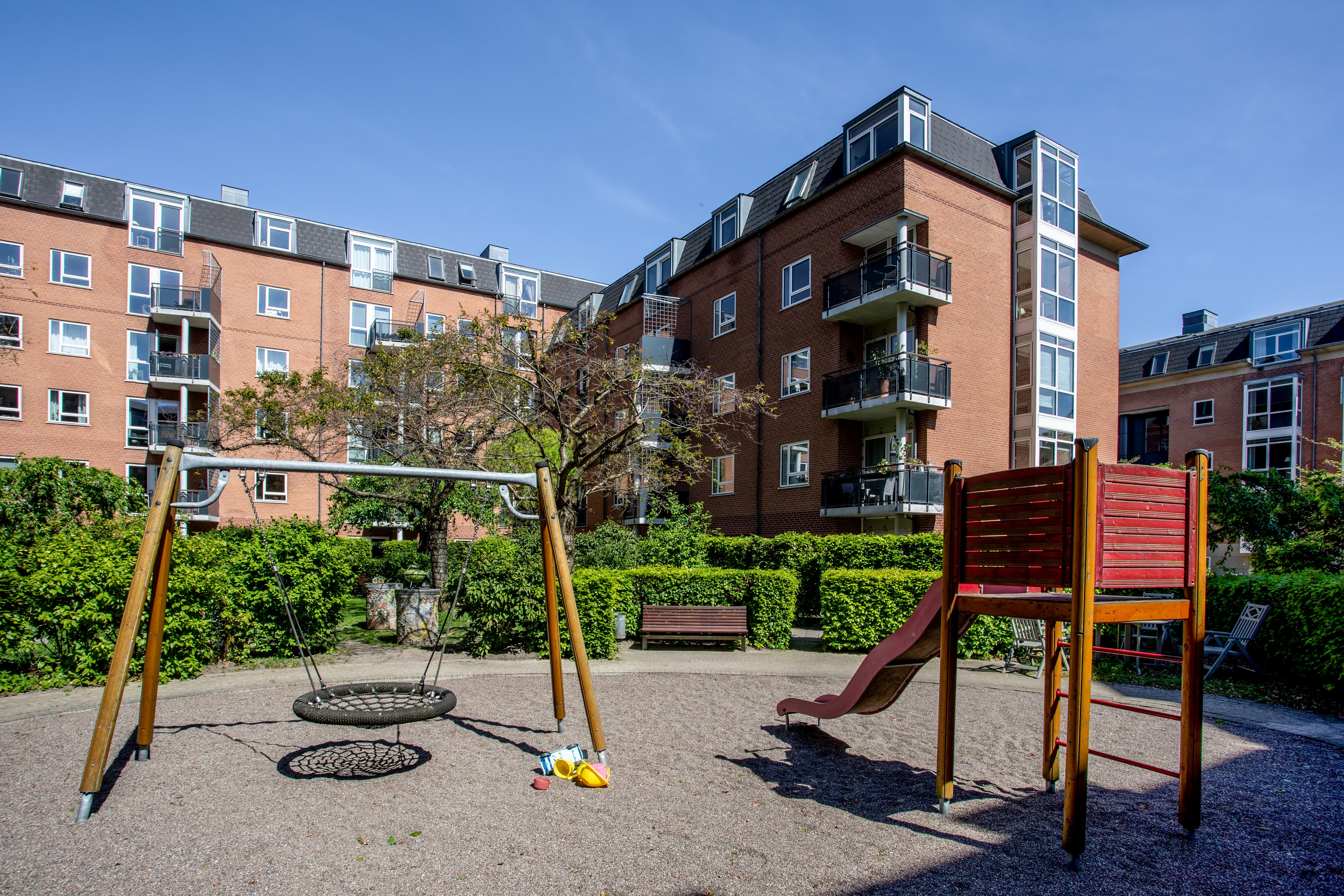 En af ejendommens gårdrum, som har en legeplads med gynge og rutsjebane, ejendommen er Østerfælledtorv, som er placeret på Østerbro i København.