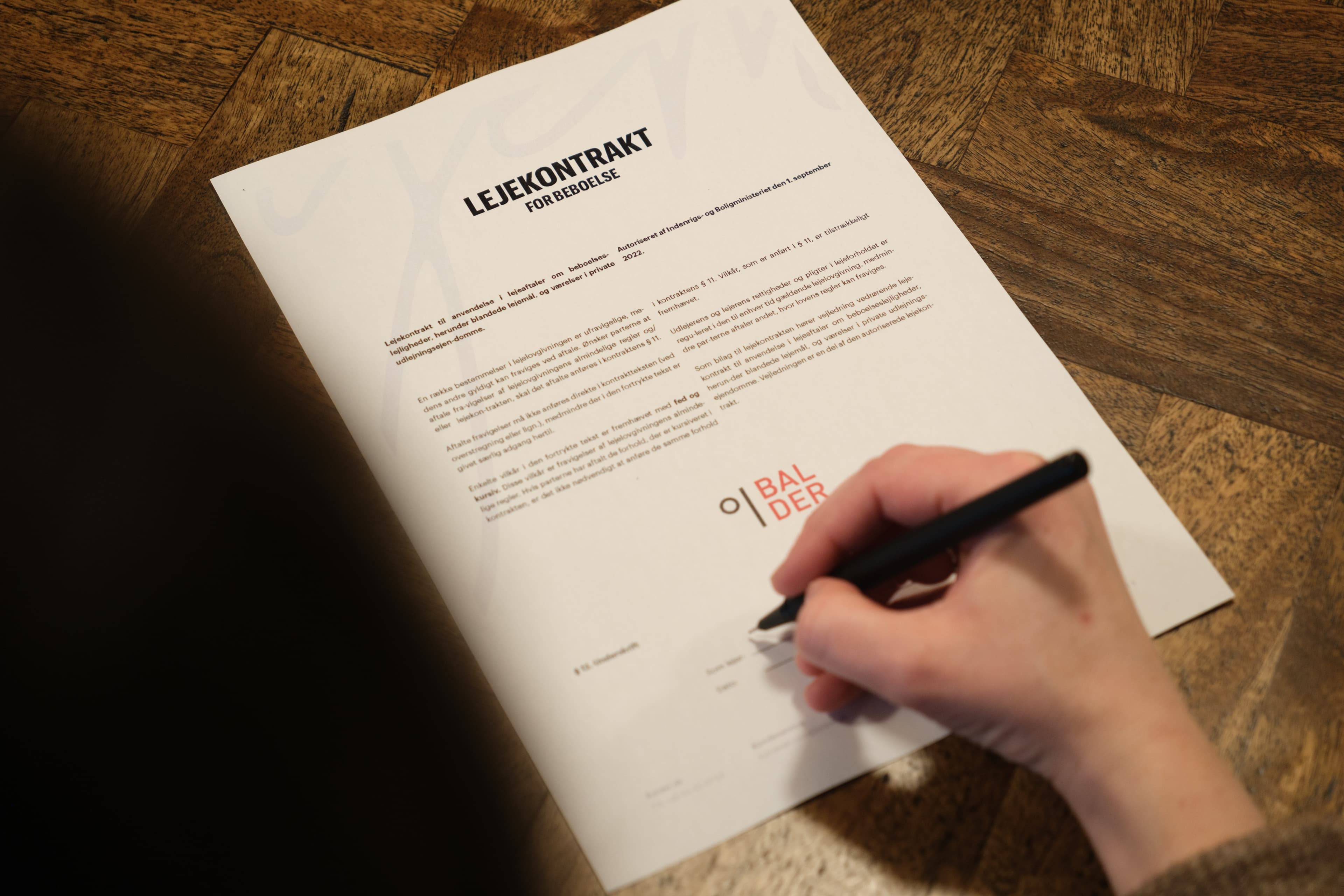 A woman is signing a tenancy agreement from Balder.