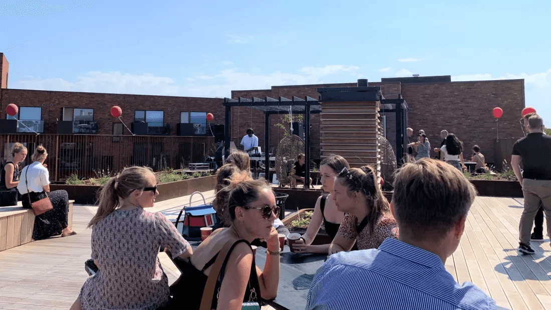 People sit on the rooftop terrace at the Carlsbakken property in Hillerød.