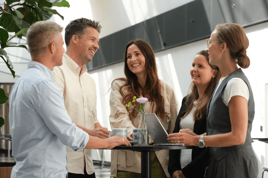 Employees at Balder Denmark stand in a circle and talk together