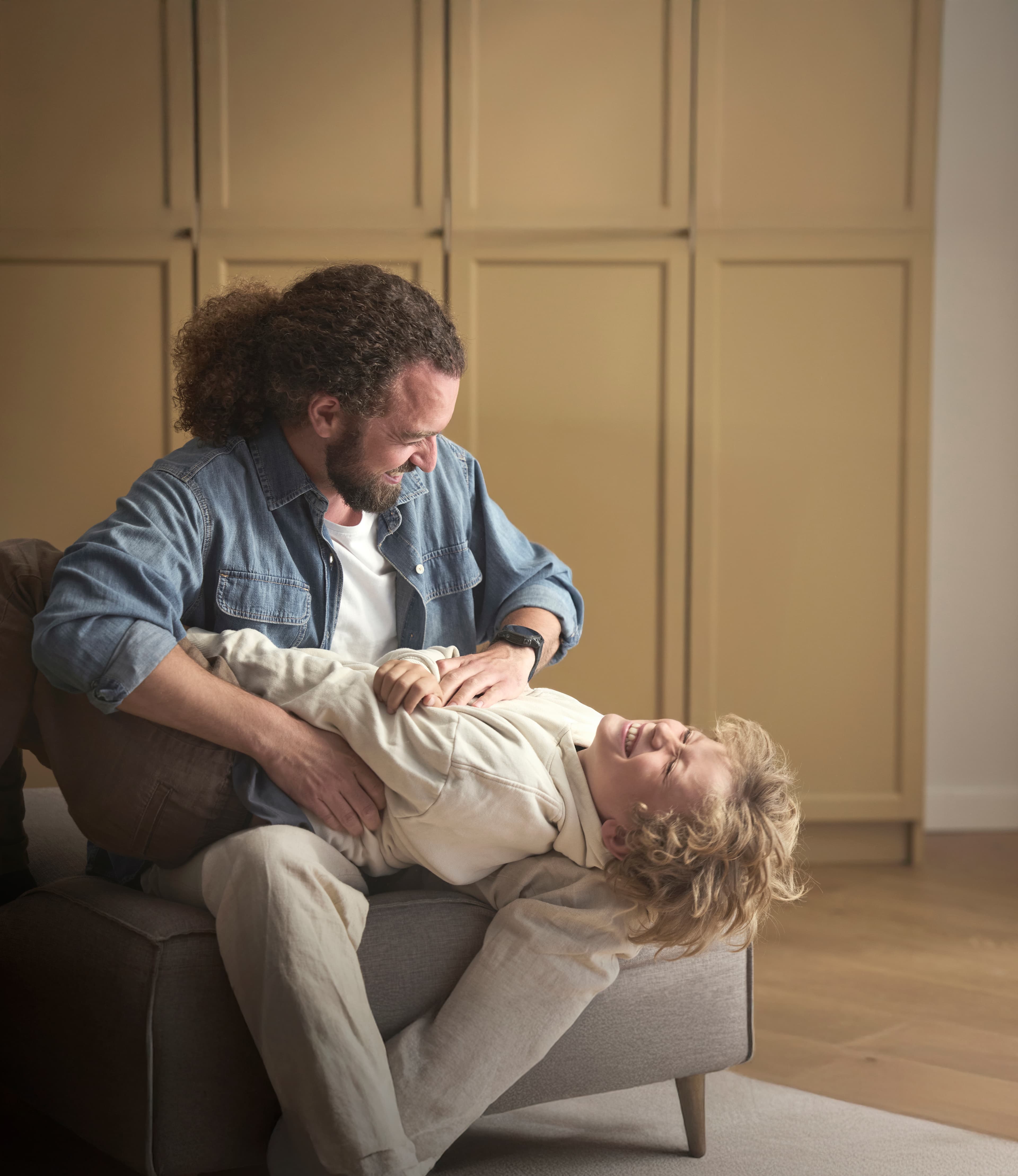 Far kilder sin søn på sofaen