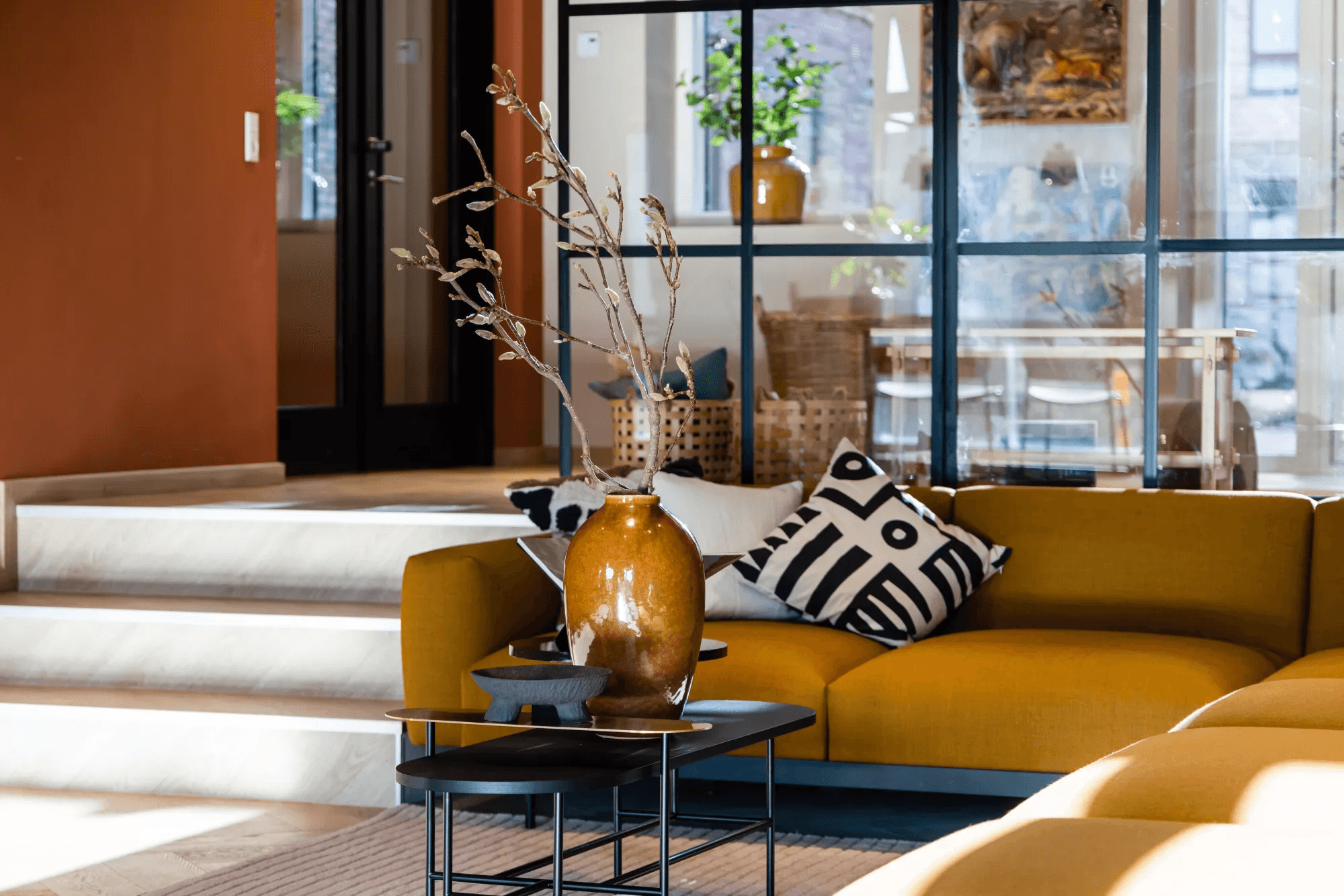 Gul sofa og sofabord med plante i fælleslokalet i ejendommen Rubinhavne i Høje Taastrup