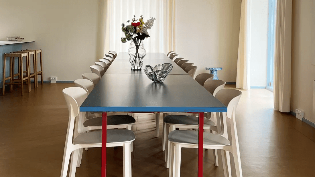 Common room with a long table and chairs in the Øresund Park property at Amager Strand.